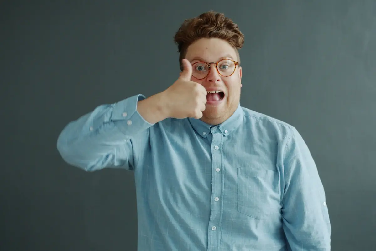 A smiling man in glasses giving a thumbs up